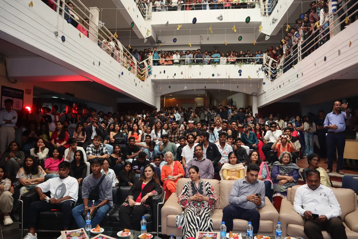 An audience filling the atrium and its balconies during a college event.